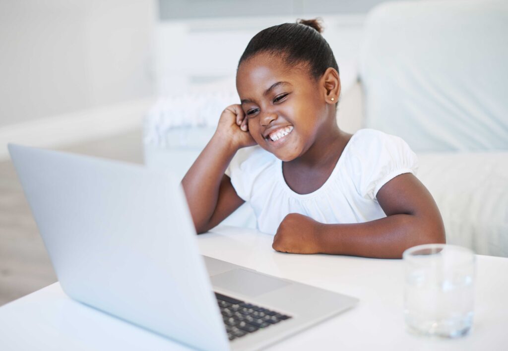 girl-sitting-on-chair-over-a-laptop-and-smiling